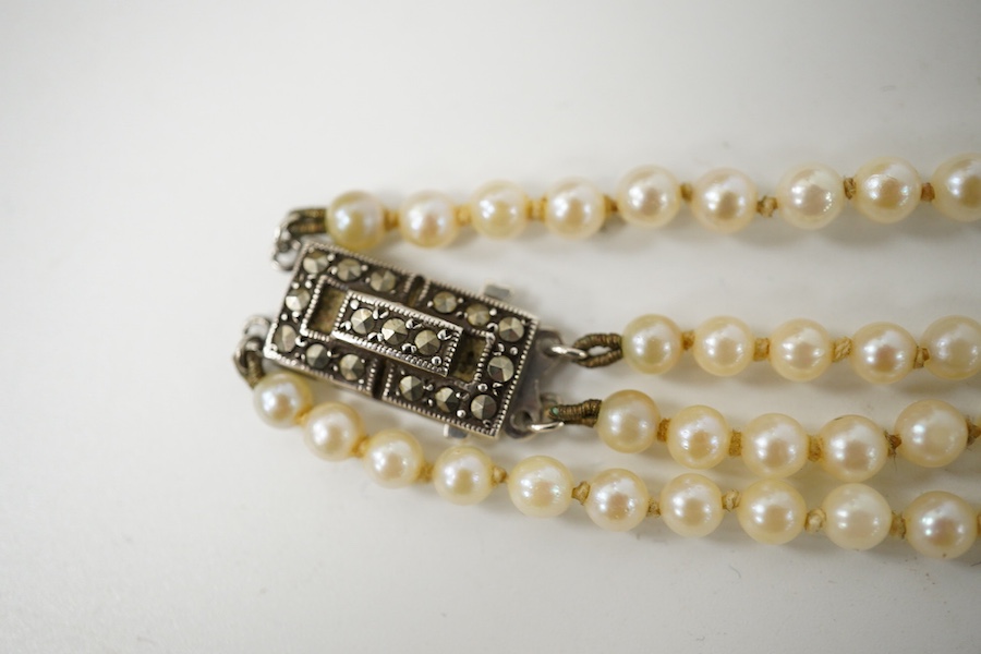 A double strand graduated culture pearl necklace, with marcasite set sterling clasp, 46cm and one other single strand cultured pearl necklace. Condition - fair